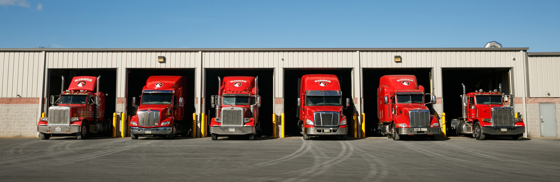 Various size trucks lined up outside of garage bay