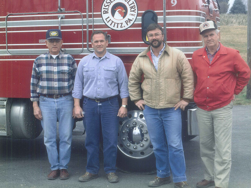 Four men standing in front of Risser's Poultry truck