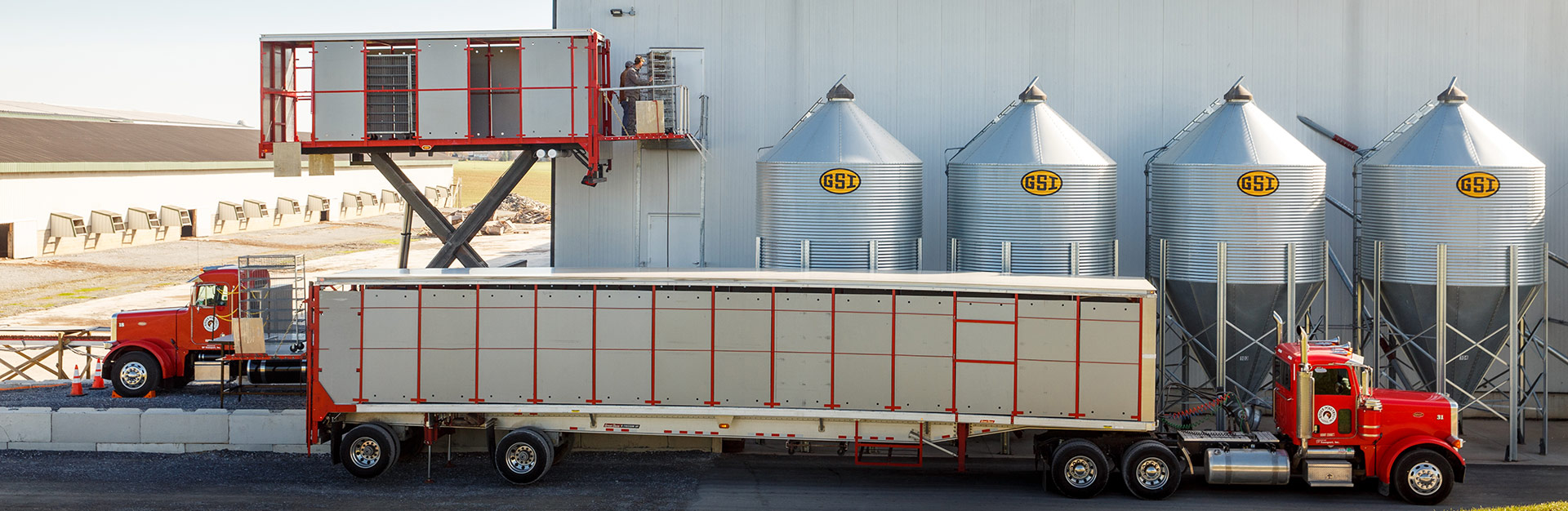 Transport truck and lift truck parked outside of a farm